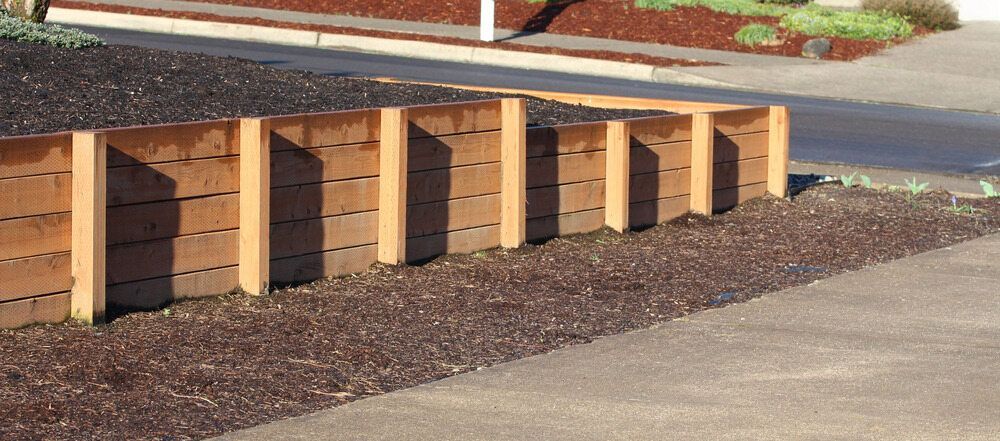 Brick-colored Concrete Benches Along a Sidewalk Beside a Road and Landscaped Bed — Fencing Around in Garbutt, QLD