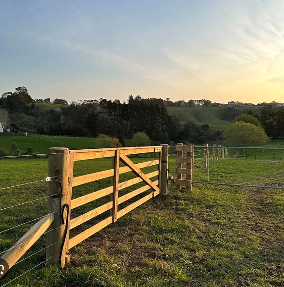 Sunlit Wooden Farm Gate Beside a Fenced Grassy Field at Sunset — Fencing Around in Garbutt, QLD