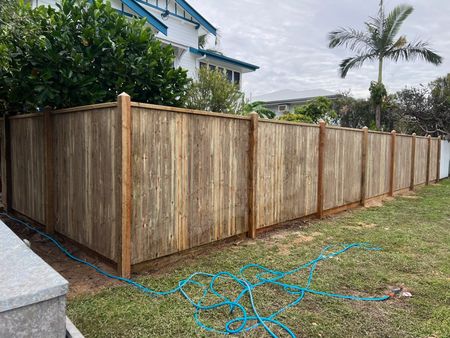 Wooden Privacy Fence Along a House Yard, With a Blue Hose on the Ground — Fencing Around in Garbutt, QLD