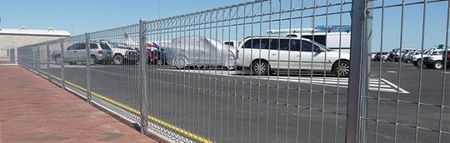 Chain-link Fence Along a Parking Lot With Rows of Cars Under a Clear Blue Sky — Fencing Around in Garbutt, QLD