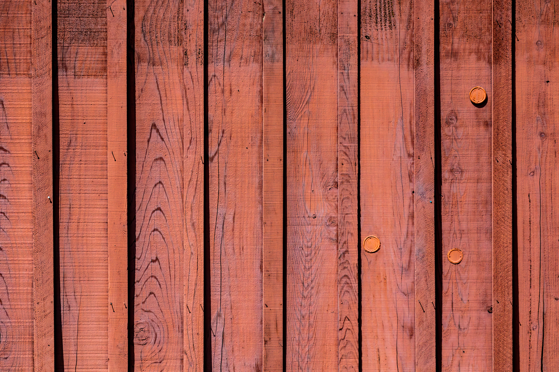 Weathered Orange Wooden Fence Boards With Knots and Nail Heads — Fencing Around in Garbutt, QLD