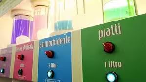 Una fila di colorati dispenser di detersivo con pulsanti etichettati per prodotti come 