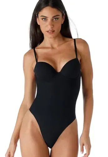 Una donna indossa un body nero aderente con spalline sottili e scollo a cuore su sfondo bianco.