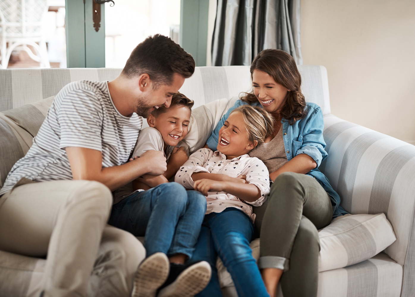 A family is sitting on a couch in a living room.