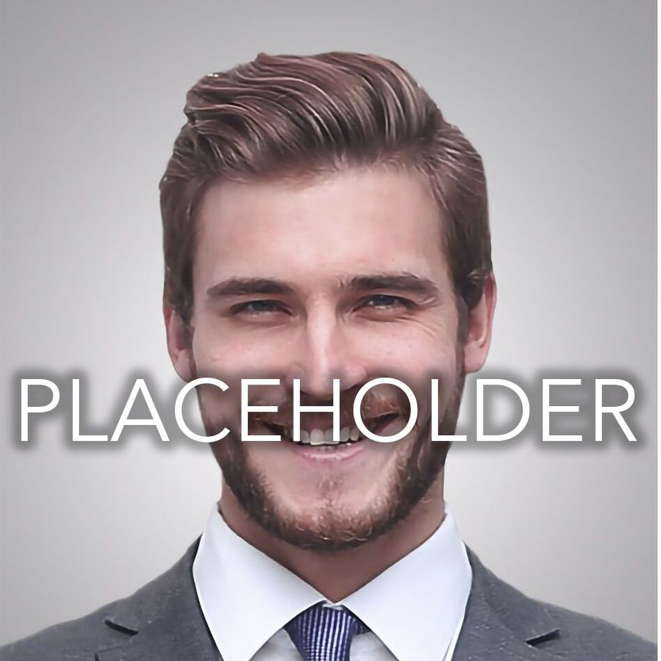 A man in a suit and tie is smiling in front of the word placeholder