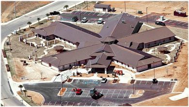 An aerial view of a large building with a parking lot in front of it