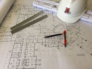 A hard hat is sitting on top of a blueprint.
