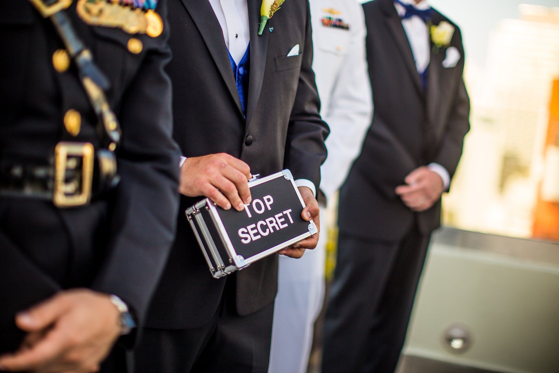 A man in a suit is holding a box that says top secret.