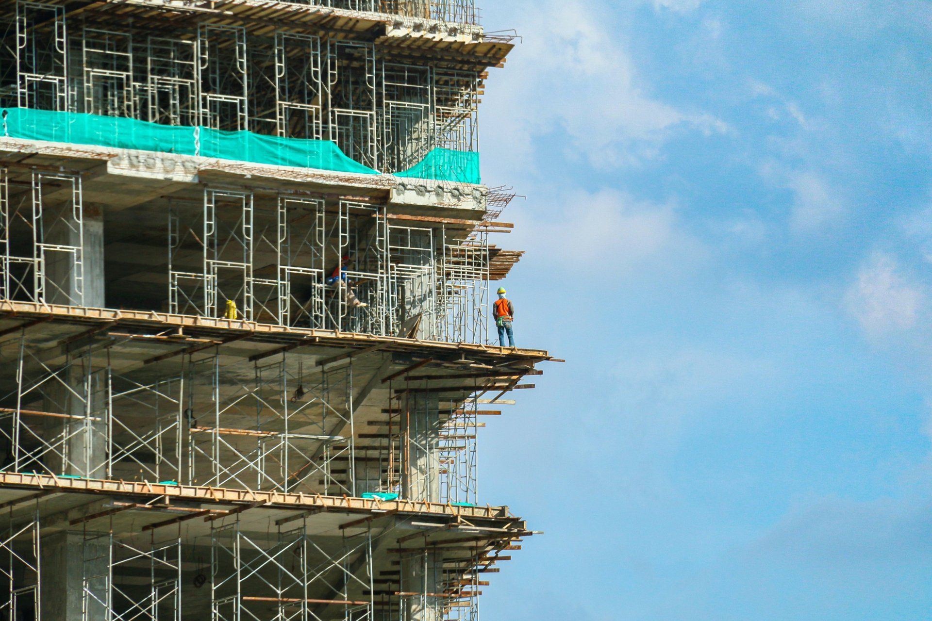 A man is standing on top of a building under construction.