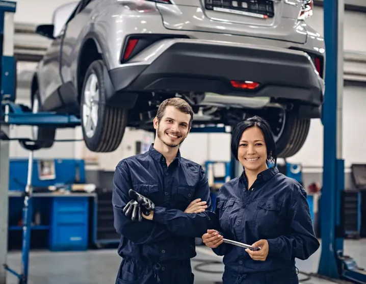 Two technicians in garage with vehicle raised behind | Auto Brakes & Lube