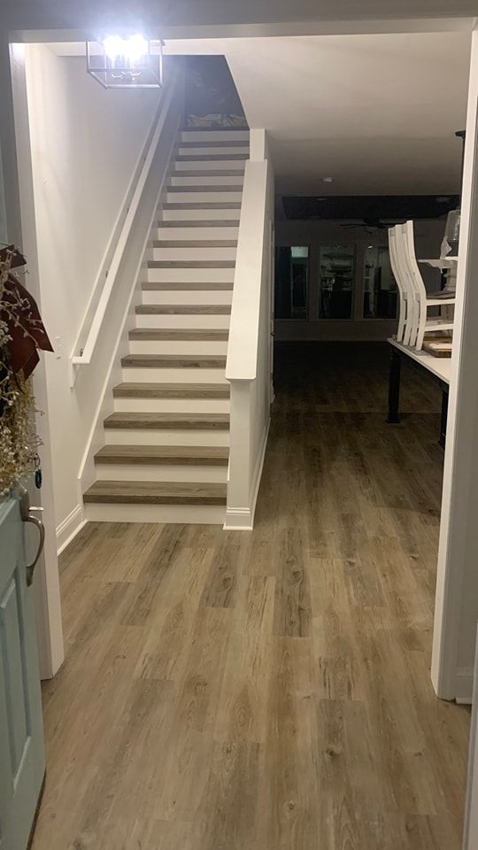A hallway with stairs leading up to the second floor of a house.