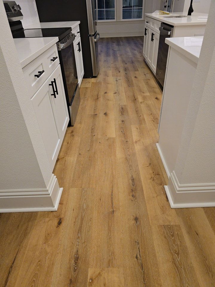 A kitchen with hardwood floors and white cabinets.