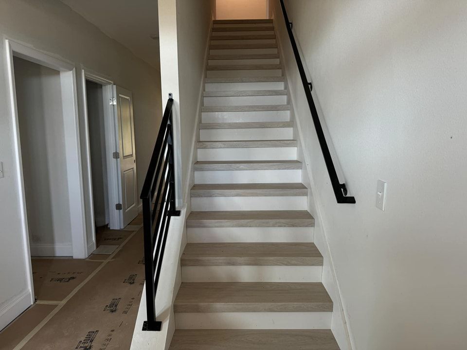 A staircase in a house with a black railing