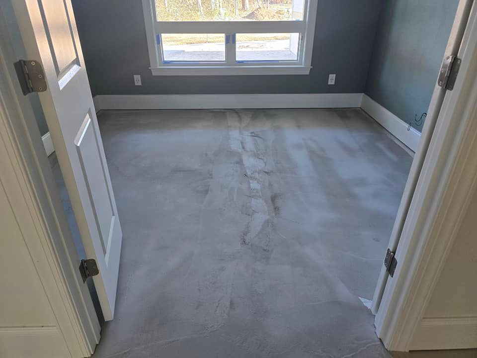 A bedroom with a carpeted floor and a window.