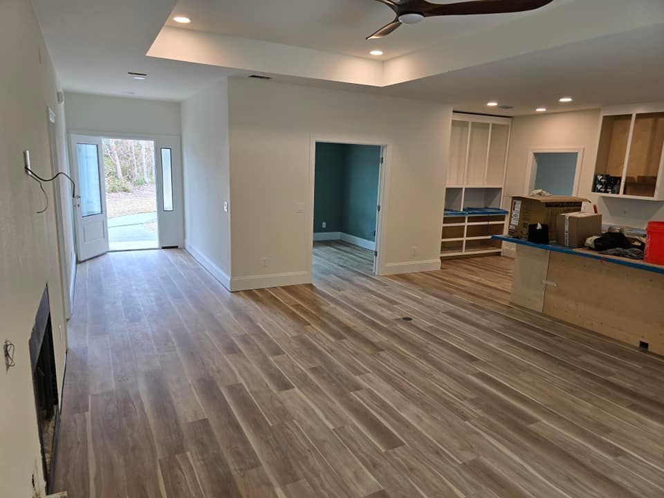 A living room with hardwood floors and a ceiling fan.