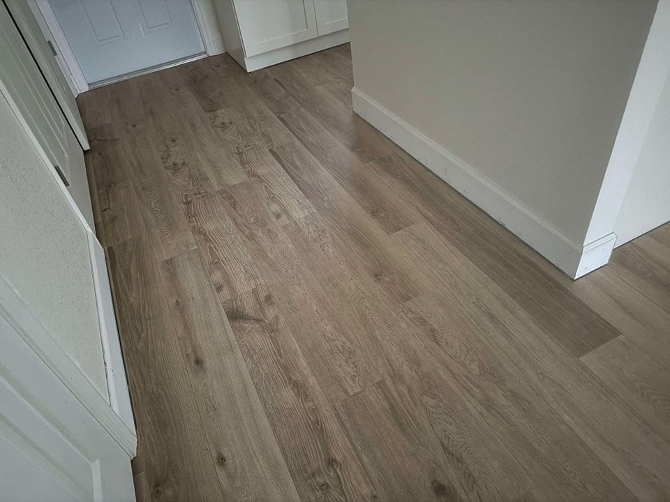 A hallway with a wooden floor and white walls.