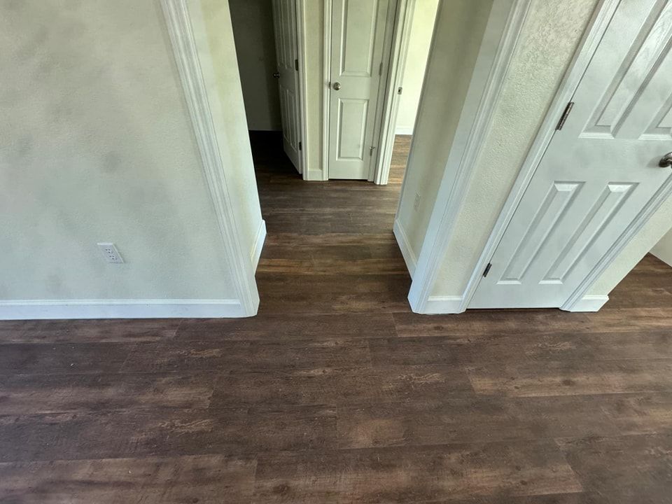 A hallway with hardwood floors and white doors in a house.