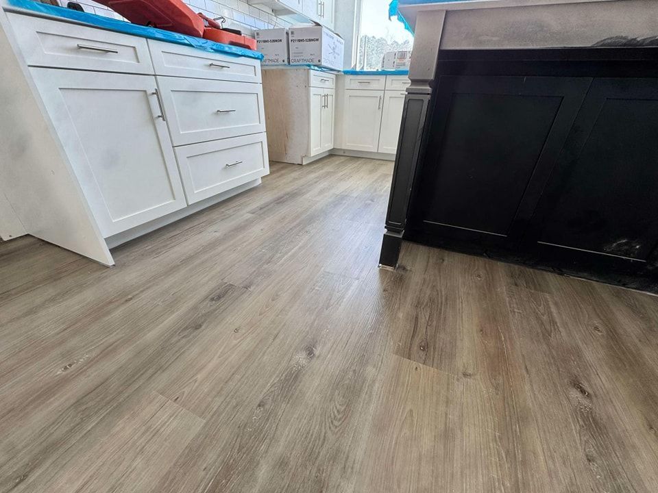 A kitchen with hardwood floors and white cabinets.