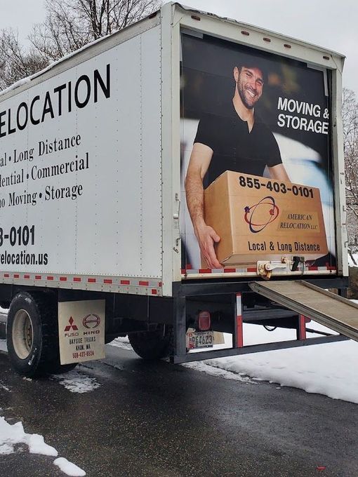 Moving truck with a ramp open, advertising relocation services.