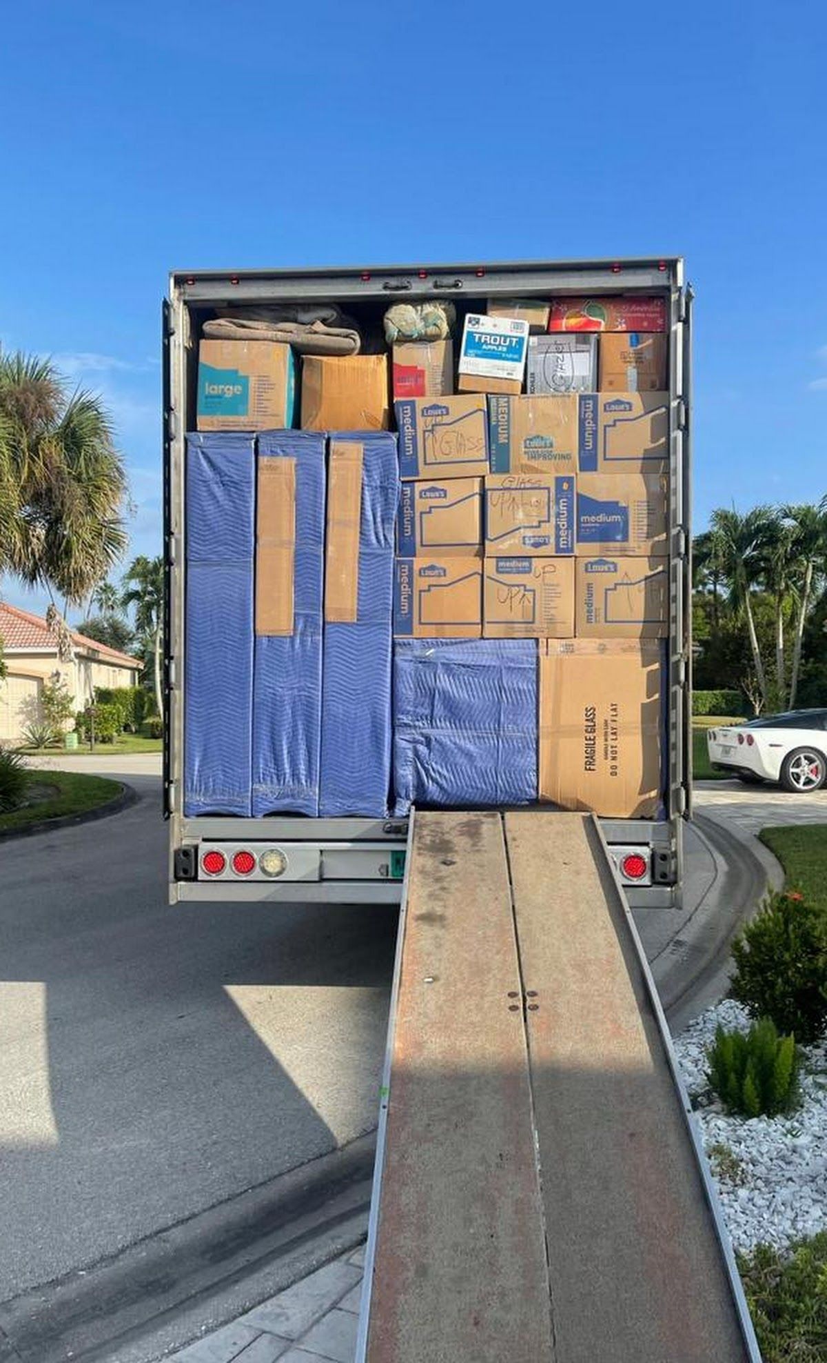 Moving truck loaded with boxes, ramp extended.