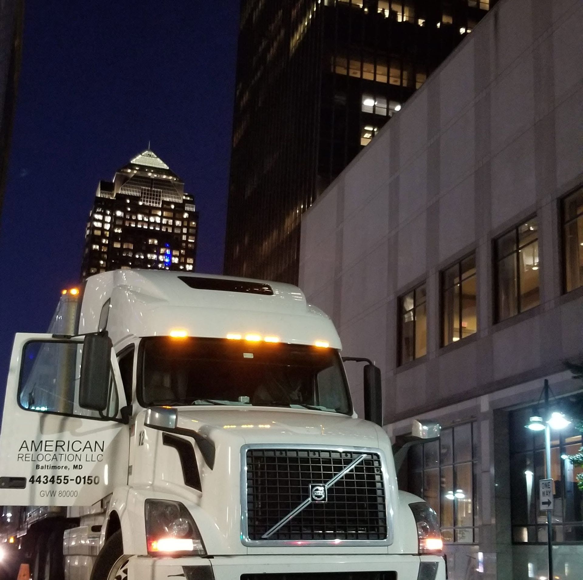 A mover loads a cardboard box into a Green Line Relocation truck.