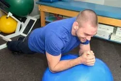 a man is doing a plank on a blue exercise ball .