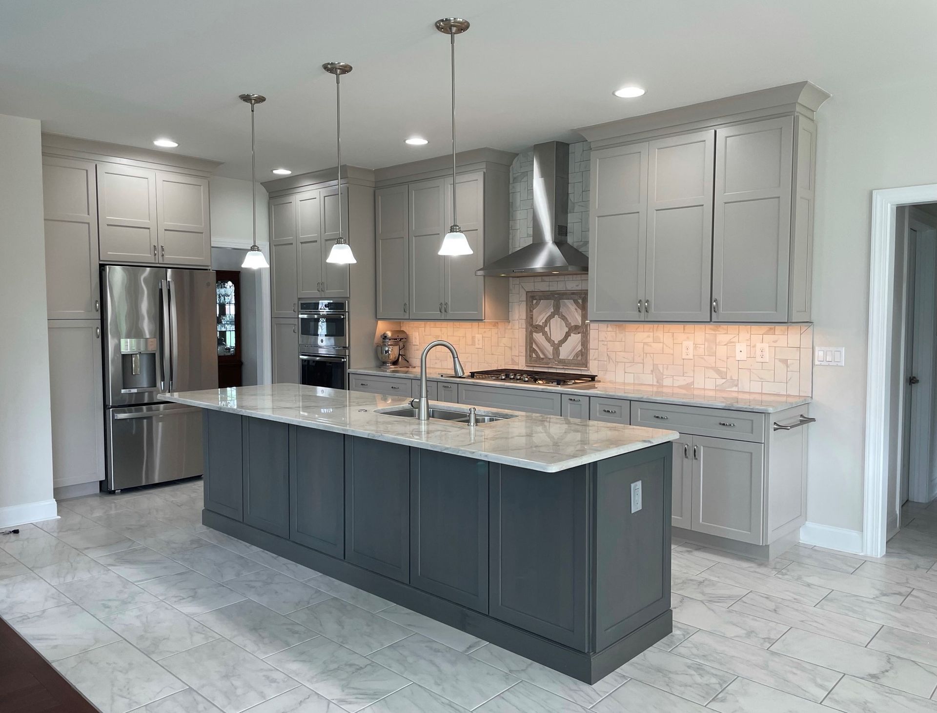 A kitchen with white cabinets and black counter tops