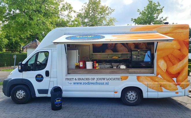 Witte foodtruck met open raam, afbeelding van friet en blauw logo, geparkeerd buiten.