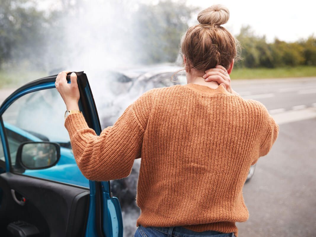 Woman holding her neck in pain after a car accident