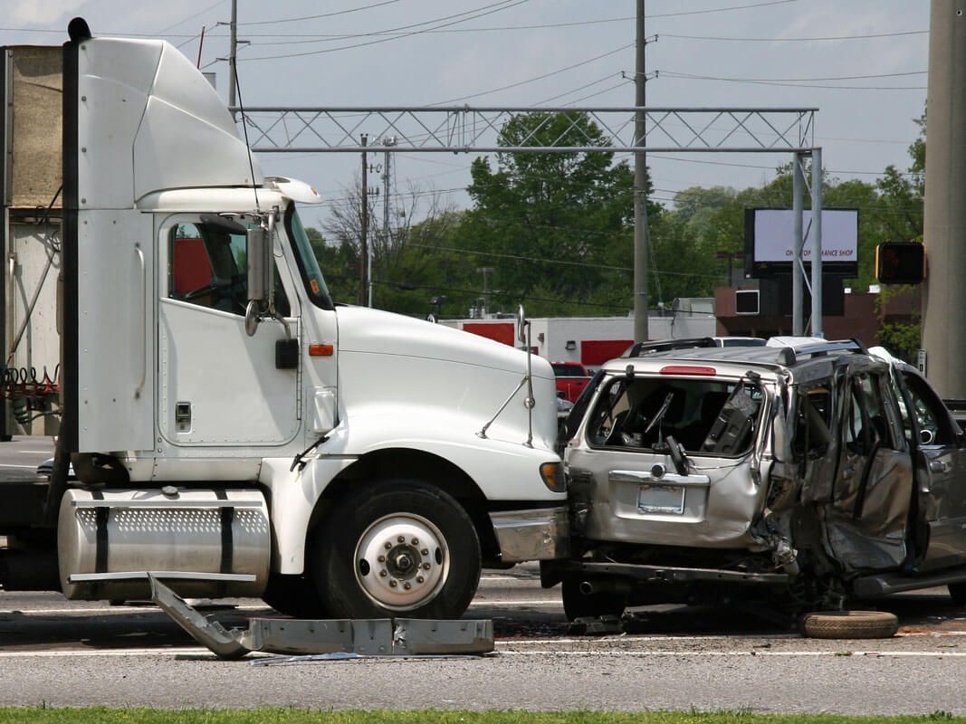 White semi truck post-collision with a silver van