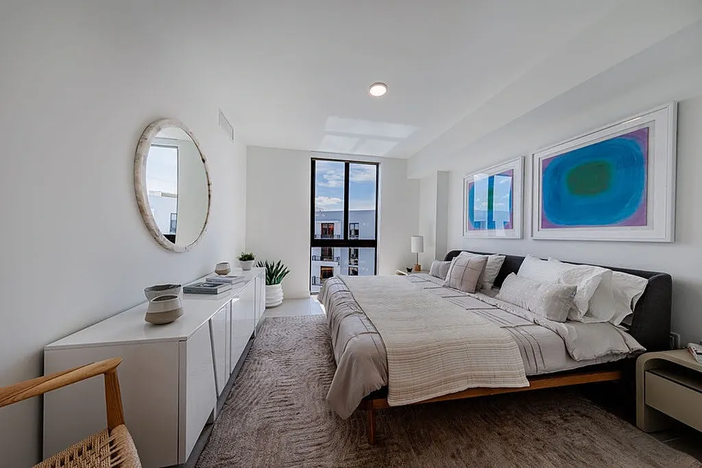 Elegant spacious bedroom featuring recessed lighting, stylish architectural design, beautiful porcelain floors and expansive window for natural light.