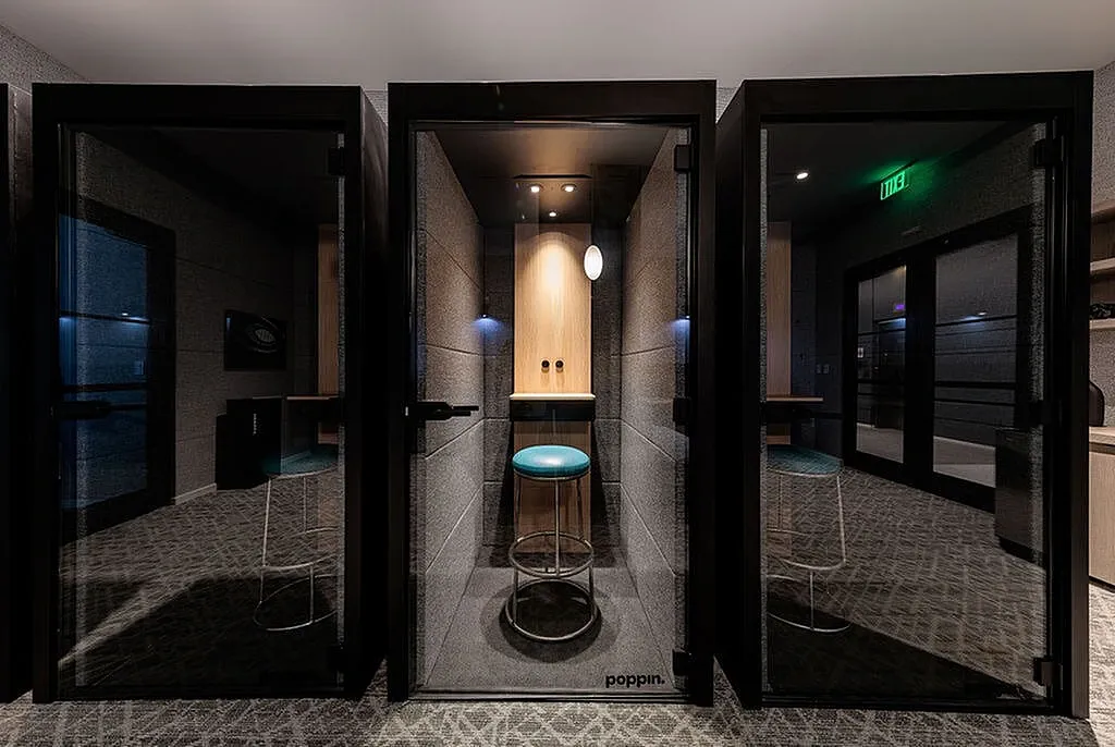 Contemporary podcast pods and office space showcasing sleek private booths with modern seating and lighting.