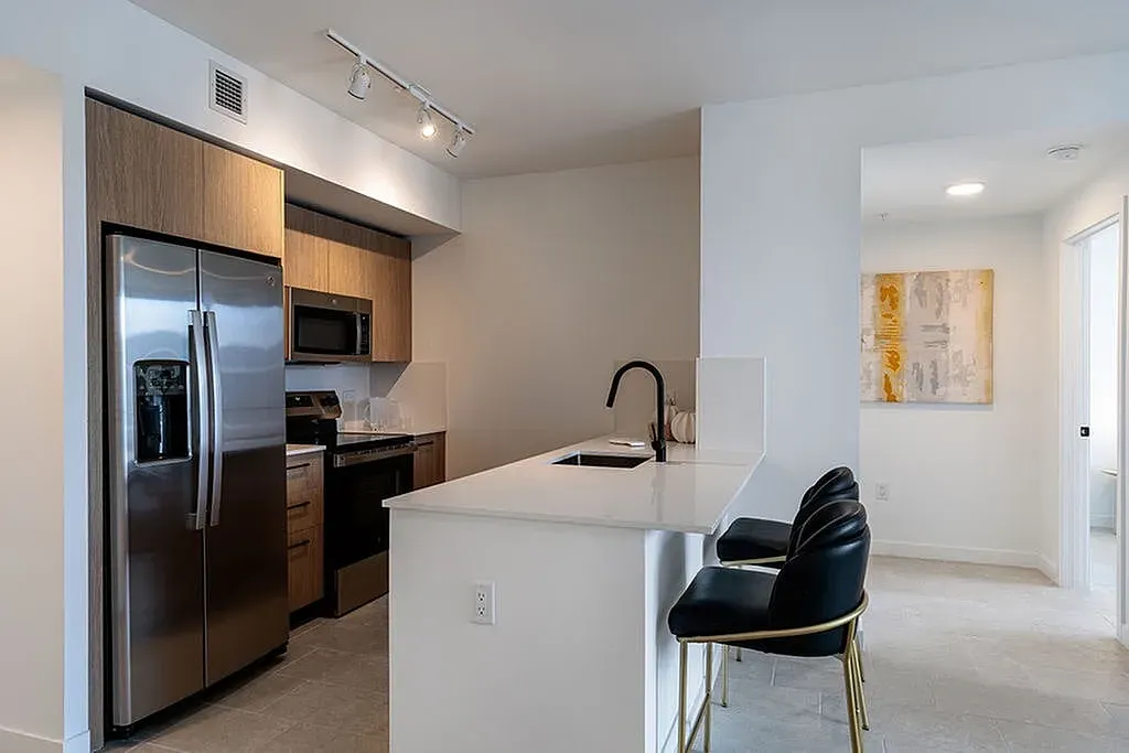 Our modern kitchen design features sleek stainless steel appliances, elegant European cabinetry, and a spacious white countertop with designer faucet.