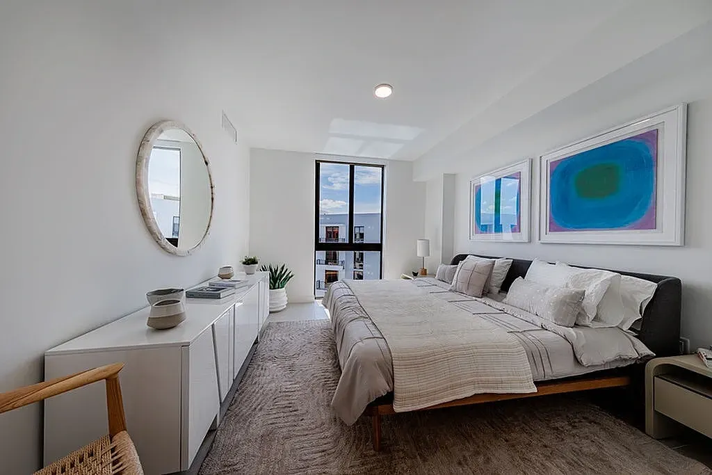 Elegant spacious bedroom featuring recessed lighting, stylish architectural design, beautiful porcelain floors and expansive window for natural light.