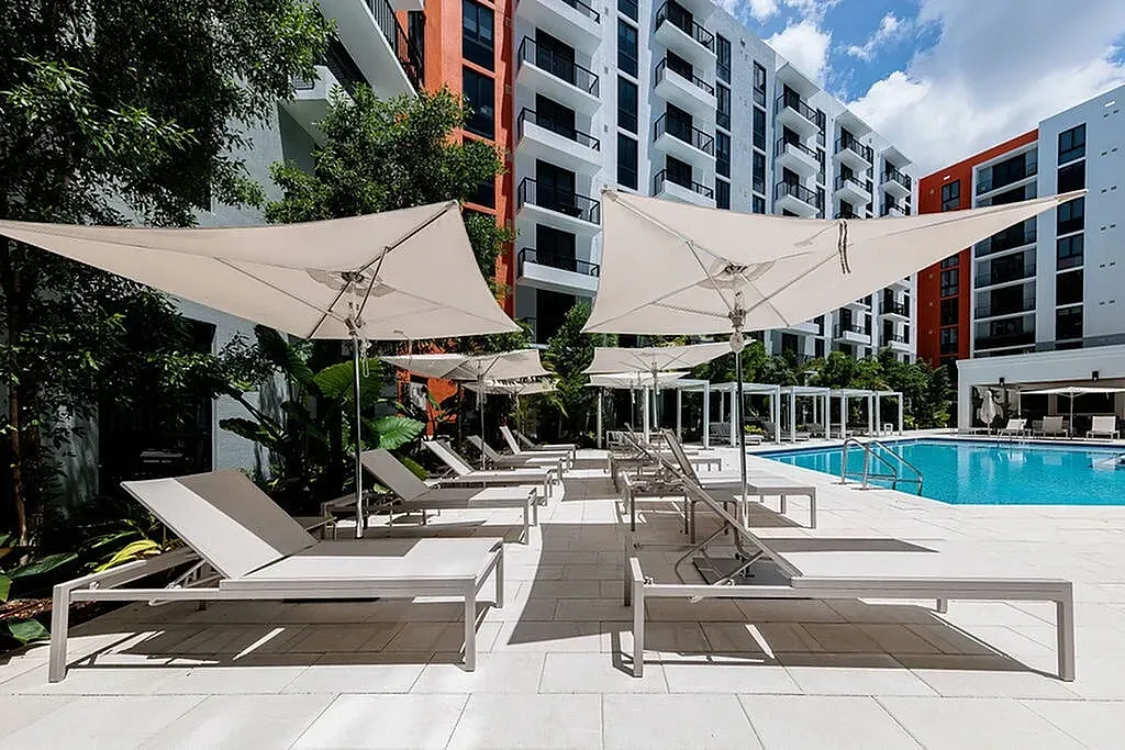 Beautiful poolside area, with stylish loungers, and elegant shades.