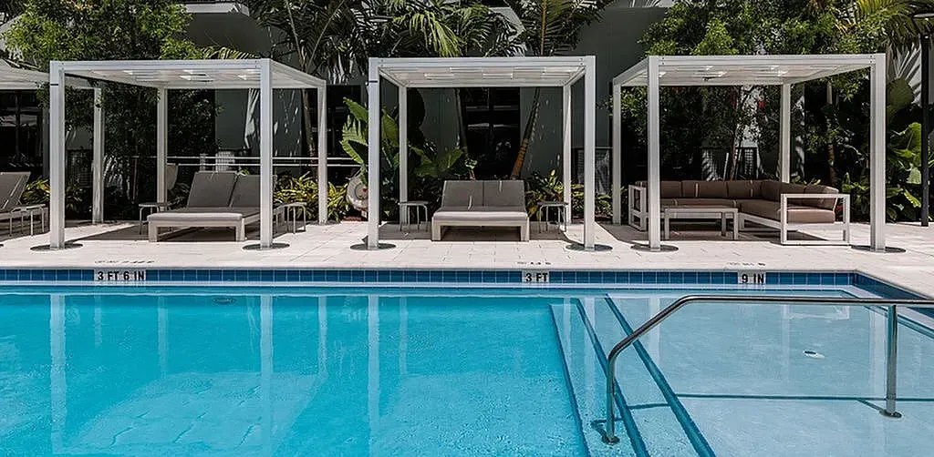 Luxurious outdoor pool area with stylish cabanas and lush greenery, perfect for relaxation and leisure.
