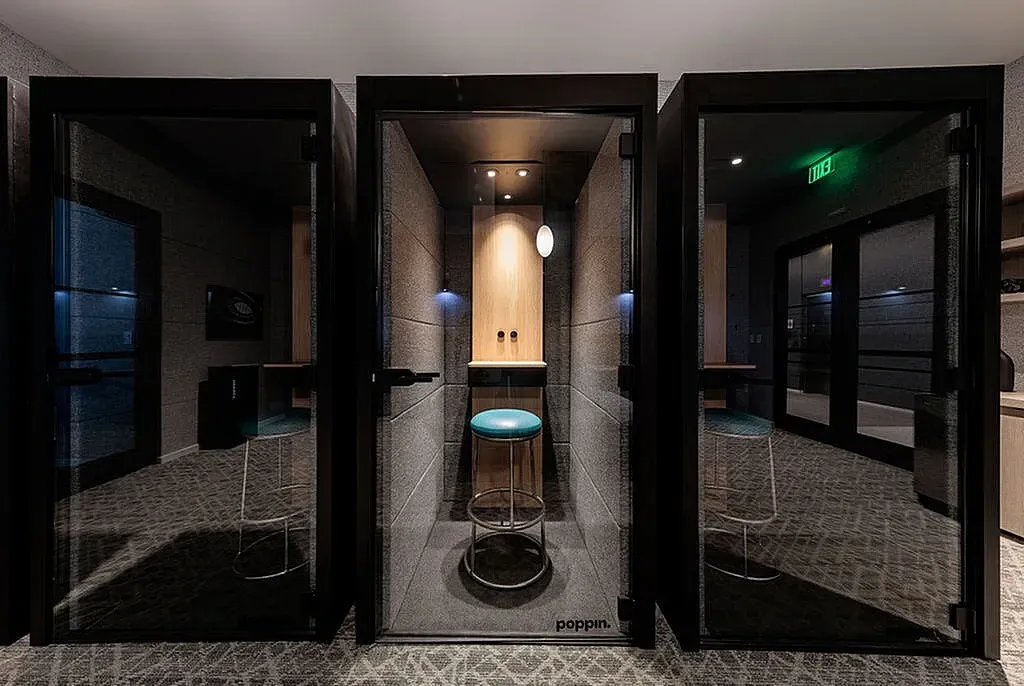 Contemporary podcast pods and office space showcasing sleek private booths with modern seating and lighting.