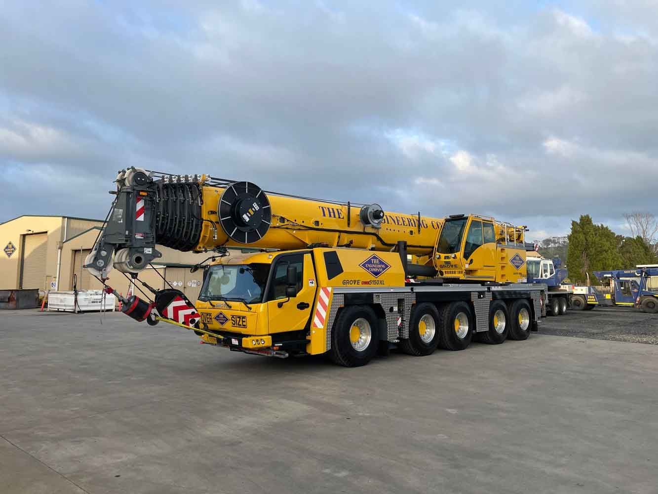Yellow mobile crane parked on concrete.