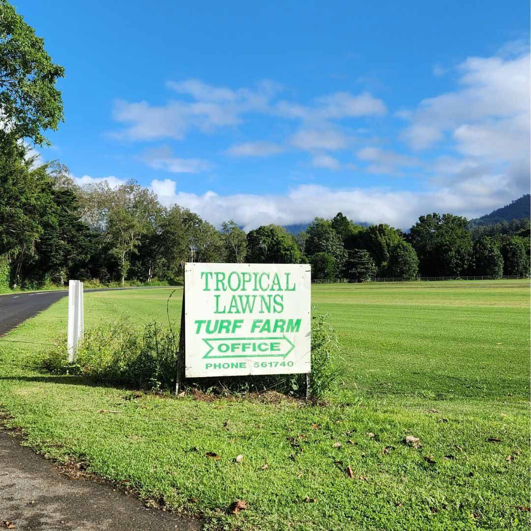 Green Roadside Sign for Tropical Lawns Turf Farm Office Beside a Grassy Field — Tropical Lawns in Mulgrave, QLD