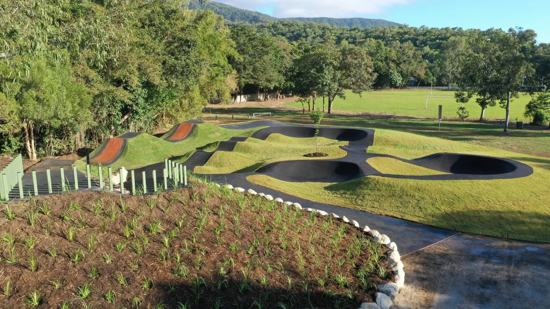 Landscaped Garden With Curved Flower Beds, Stone Paths, and Grassy Mounds — Tropical Lawns in Mulgrave, QLD