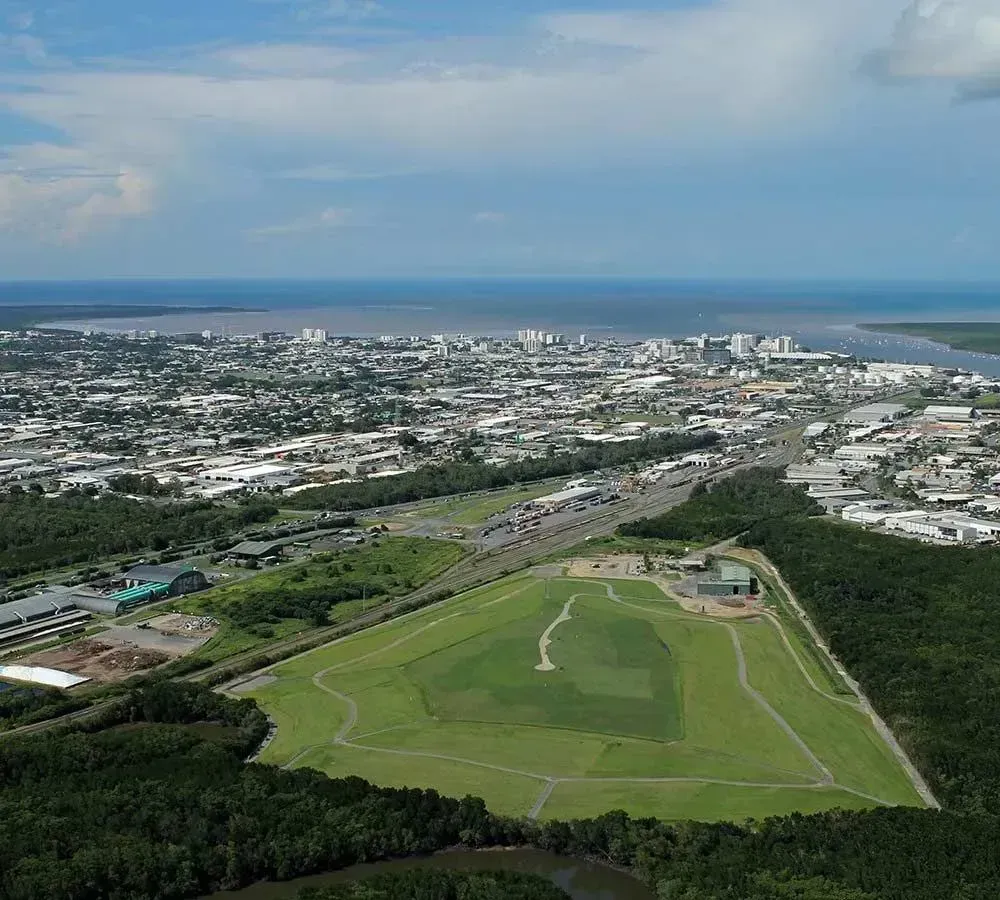 Aerial View of a Green Golf Course Beside a Coastal City and Blue Ocean — Tropical Lawns in Mulgrave, QLD