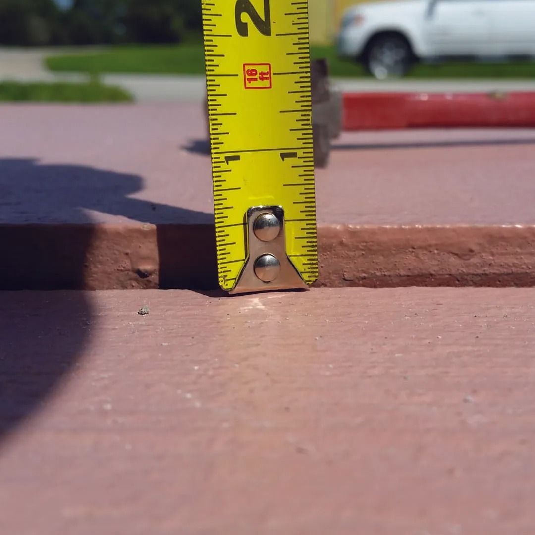 Tape measure standing on a brick ledge, measuring the height of a step outdoors.