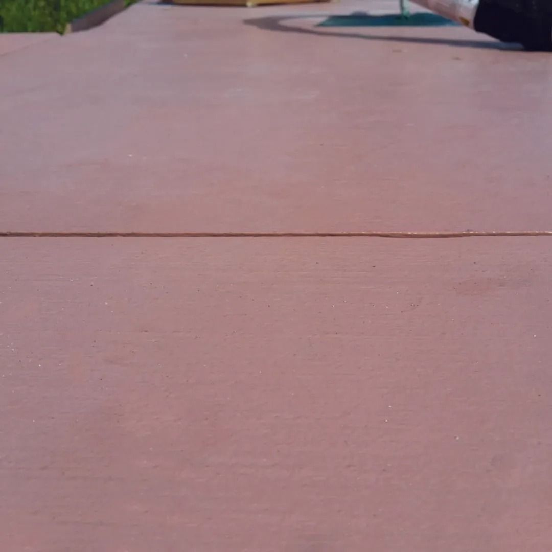 Close-up of a pink concrete surface with a horizontal seam line outdoors