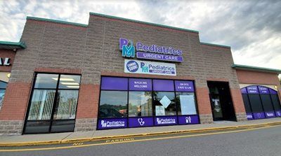 Exterior of Pediatrics Urgent Care clinic in a strip mall, purple and brick facade.