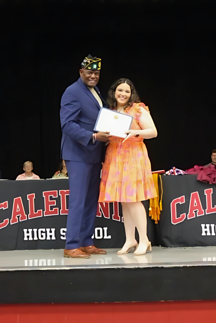 Robert Bishop  standing on a stage presenting American Legion Scholarship