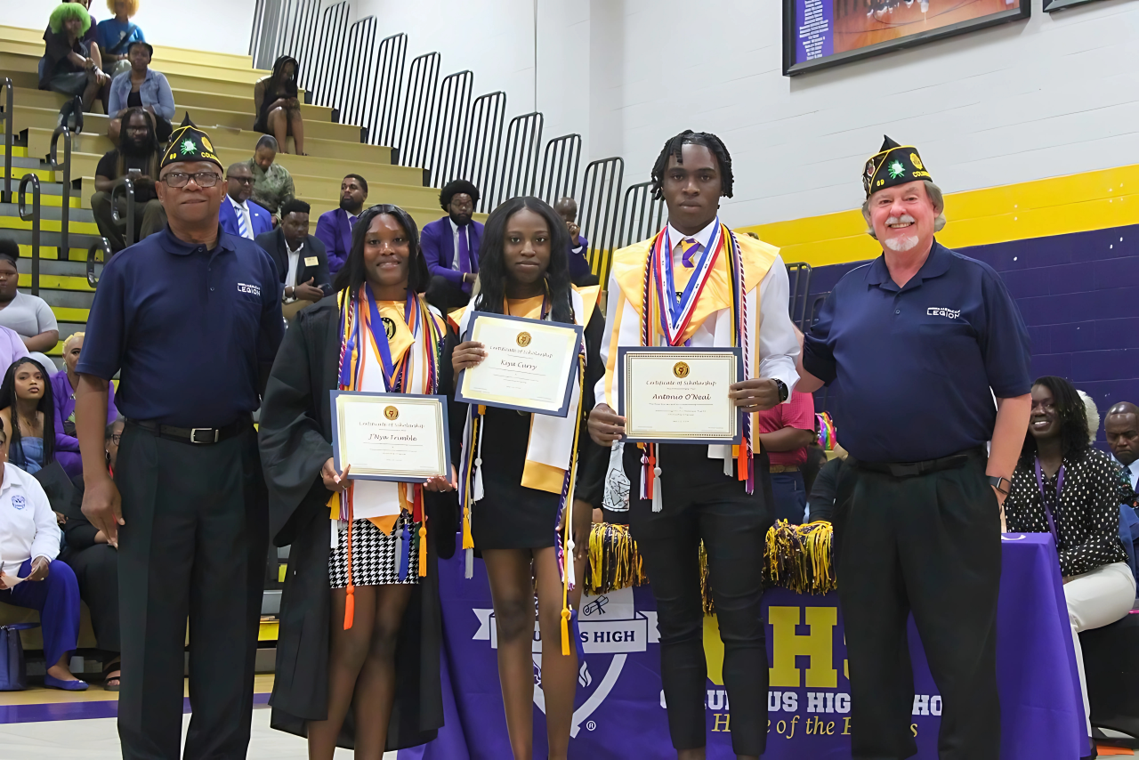 A group of people standing in a gym holding certificates