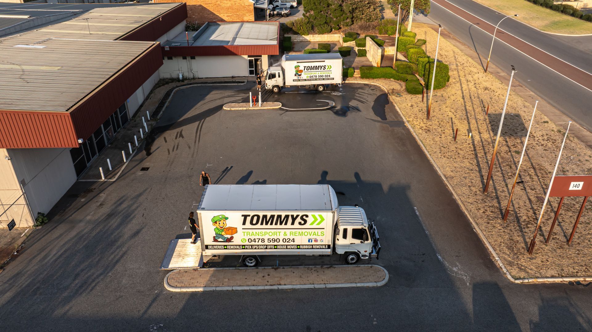 White Removalist trucks with Tommy's Transport and Removals logo  