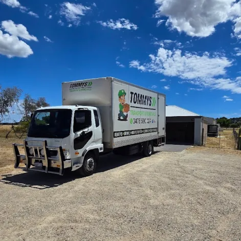 White moving truck in front of a house on a sunny day. The truck has the 