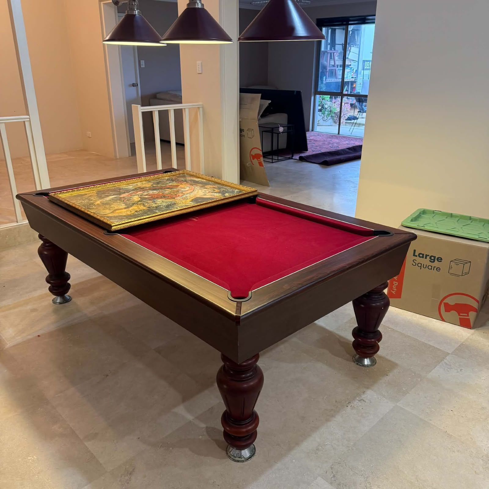 Pool table with red felt and billiard light overlaid in a modern room