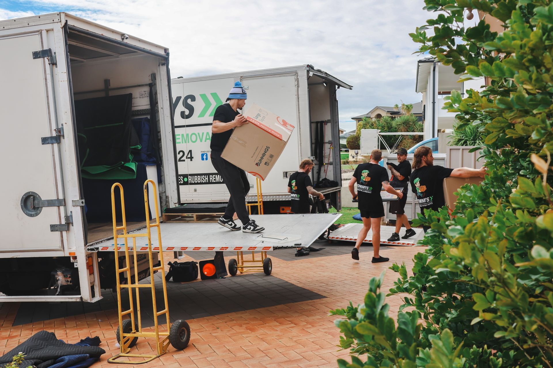 Tommy's team unloading boxes from a truck at an outdoor event setup area